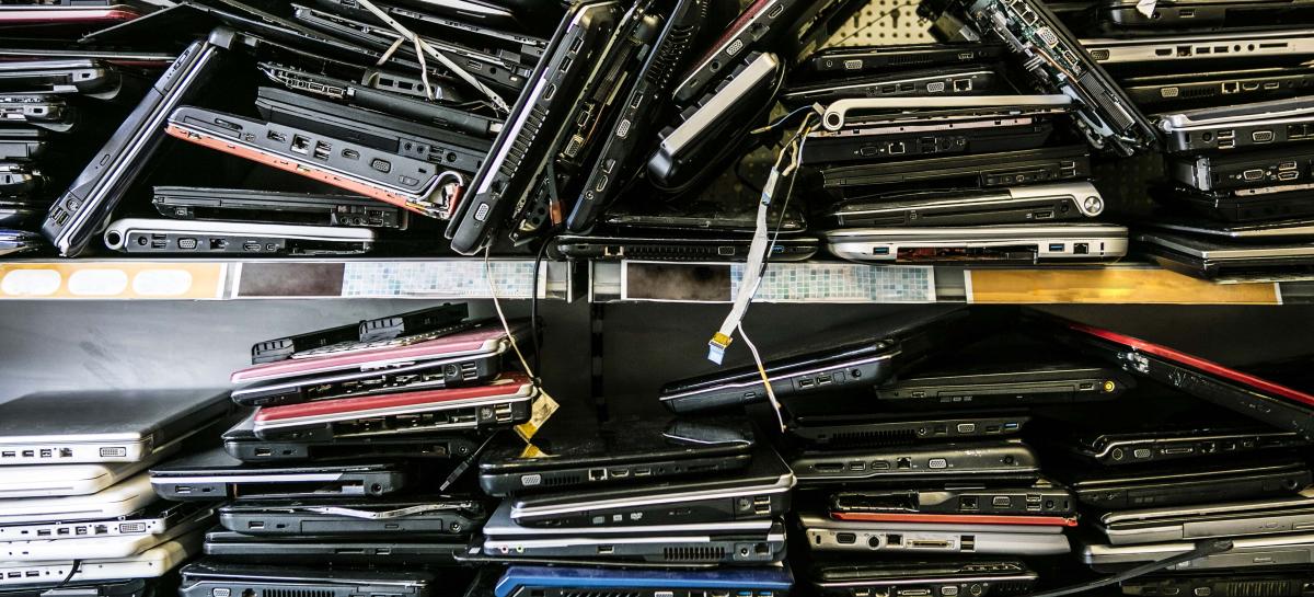 Pile of old discarded laptops on shelf waiting to be wiped