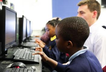 Students use the new computers with help from adults