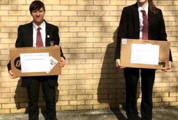 Students from Leek High School hold laptops