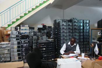 A man sitting in front of ewaste at the WEEE centre