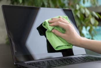 Green cloth wiping a laptop screen