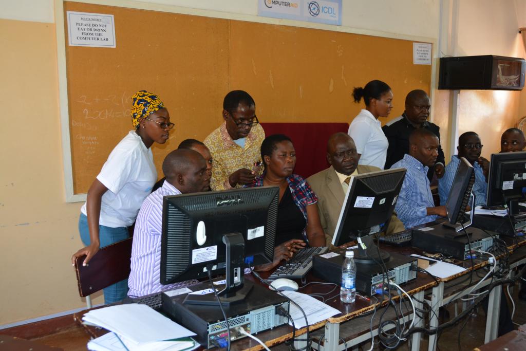 A group of teachers engage in training on computers